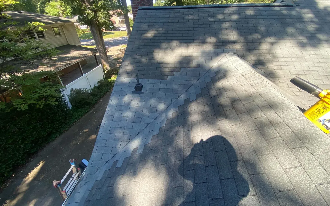 Shingle roof slope being repaired under tree shade