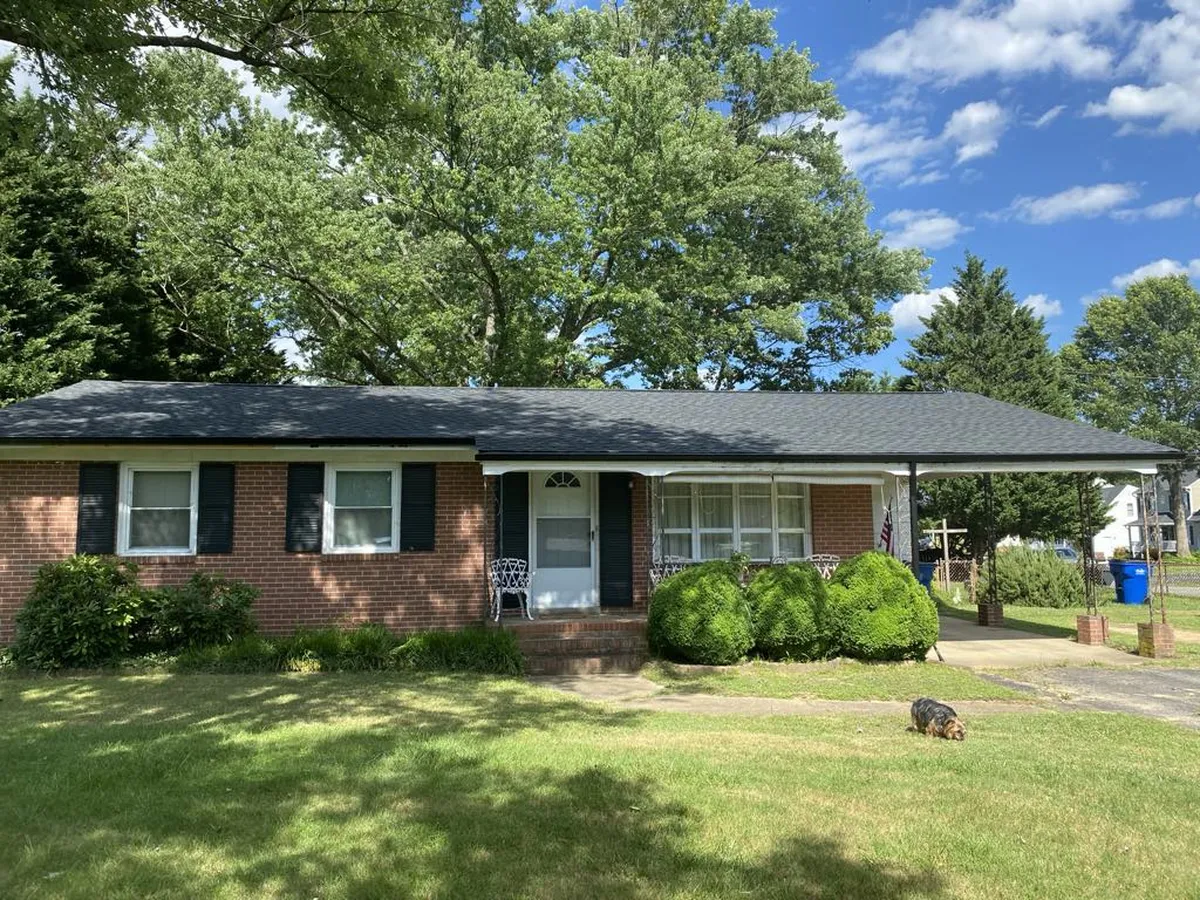Brick ranch home after a black shingle roof replacement