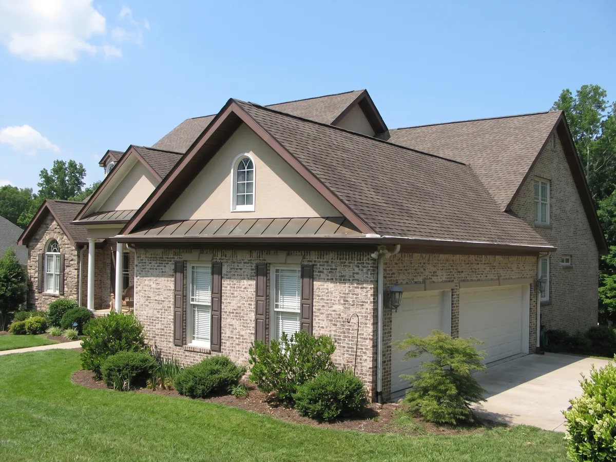 The same brick and stone home before the roof replacement, with weathered shingles